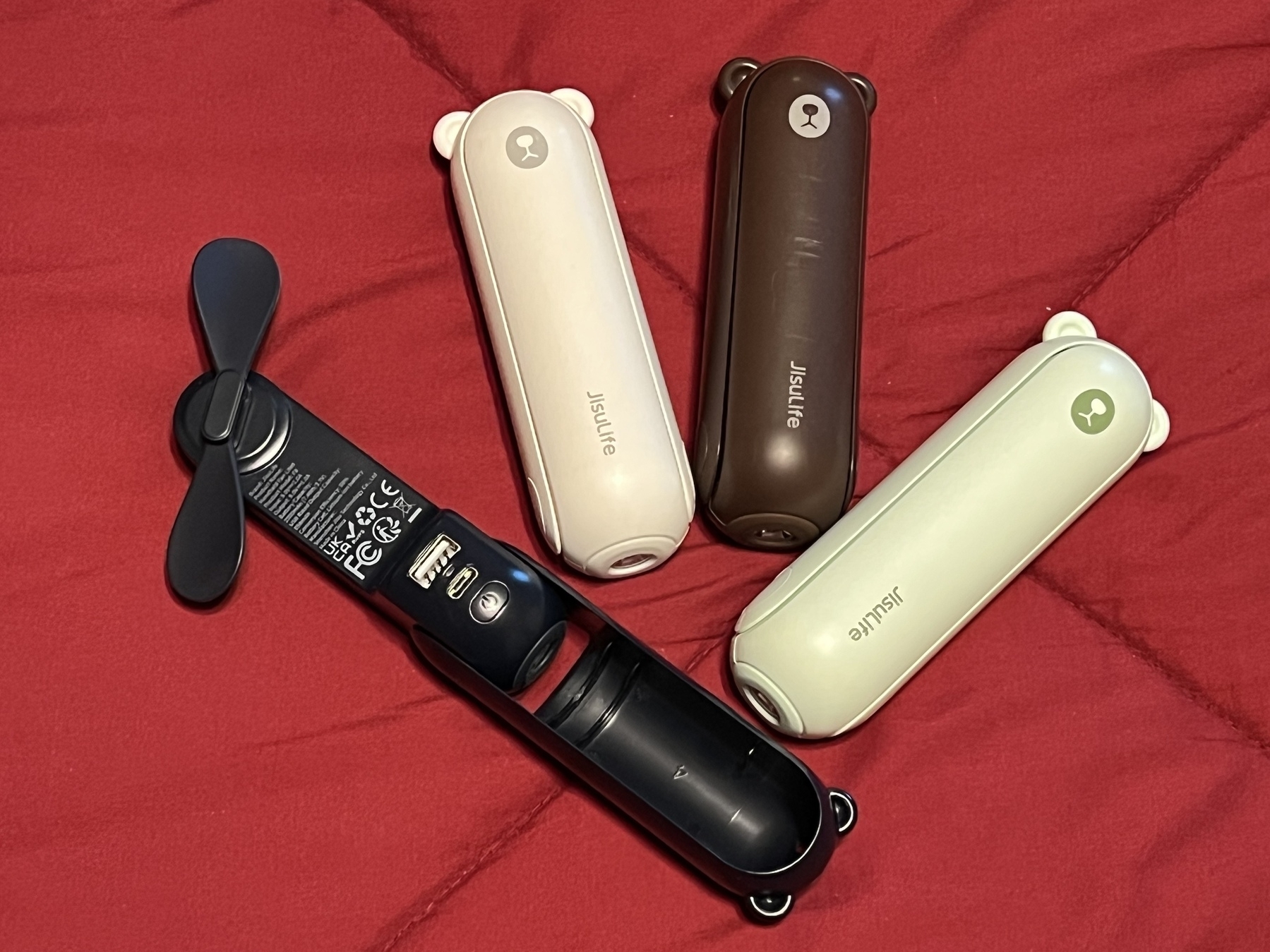 Four hand held fans representing a variety of colors.